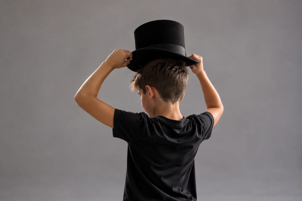 Dance Styles & Classes boy adjusting a black top hat